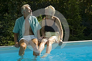 Happy elderly couple on pool