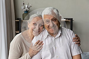 Happy elderly couple posing in home interior head shot portrait