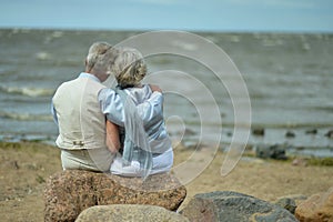 Happy elderly couple resting on tropical beach