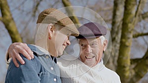 Happy elderly couple spending time in park on sunny autumn day