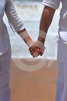 Happy elderly couple walking on tropical beach