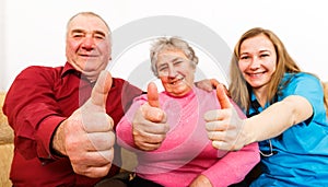 Happy elderly couple and young caregiver