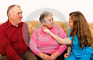 Happy elderly couple and young caregiver
