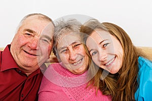Happy elderly couple and young caregiver