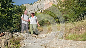 happy elderly female and male pensioners having fun on vacation walking around sights of area on a sunny day