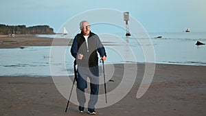 Happy elderly grandfather exercising walking stick healthy lifestyle sunset beach nature scenery