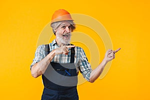 Happy elderly grey-haired man pointing