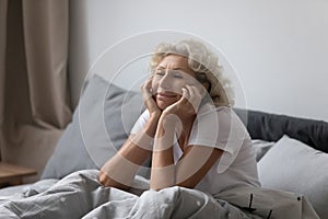 Happy elderly lady awaking in modern comfortable bedroom photo