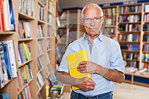 Happy elderly man in bookstore