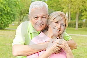 Happy elderly man embracing senior woman