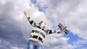 Happy elderly man pretend flying on toy airplane in sky, journey