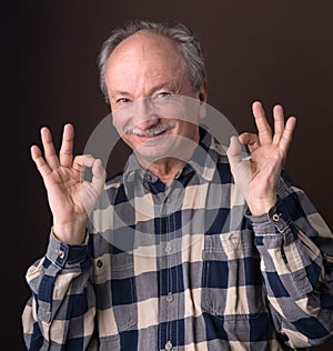 Happy elderly man showing ok sign