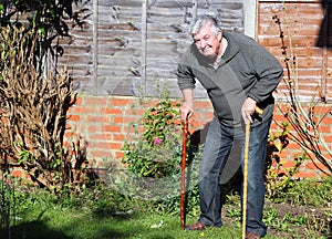 Happy elderly man with two walking sticks.