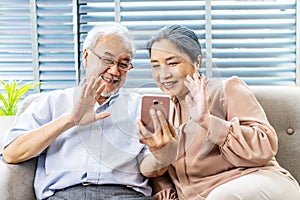 Happy elderly retired couple making video call with mobile phone, gesturing hi, having pleasant conversation,chatting with grown
