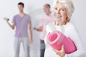 Happy elderly woman at gym