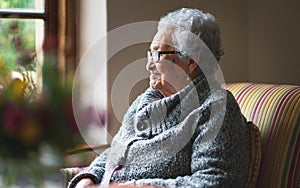 Happy elderly woman looking out window thinking of memories pensioner retirement lifestyle concept