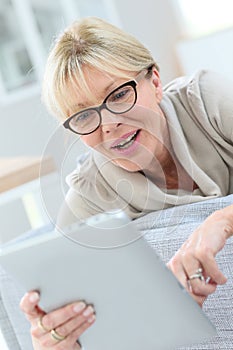 Happy elderly woman using tablet