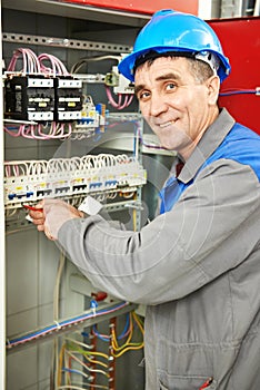 Happy electrician working at power line box