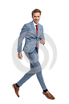 Happy elegant businessman in blue suit jumping in the air