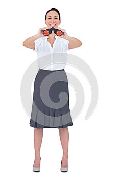 Happy elegant businesswoman looking through binoculars