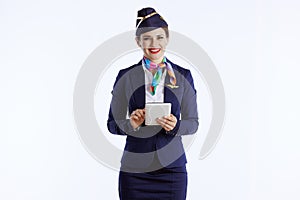 happy elegant female air hostess on white using tablet PC