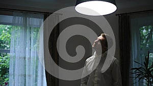 Happy elegant groom feeling tired after the wedding day celebration. Thoughtful man with eyes closed lit by lamp light