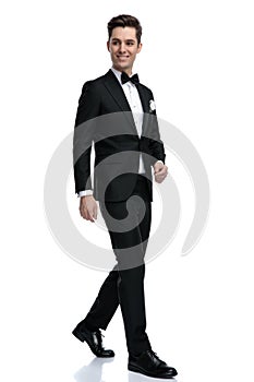 Happy elegant man smiling and walking on white background