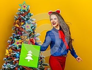 Happy elegant woman with Christmas shopping bag looking aside