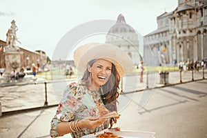 Happy elegant woman in floral dress with pizza and hat