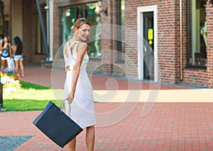Happy elegant woman walking around the city and shopping