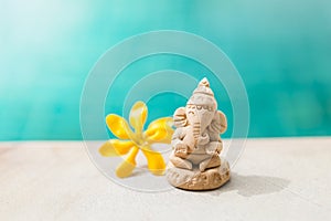 Happy elephant clay sculpture with yellow flower on swimming pool edge