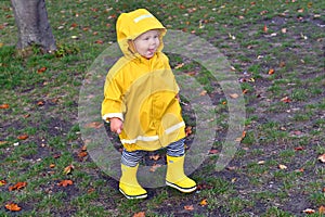 Happy emotional kid enjoing rainy weather in the park photo