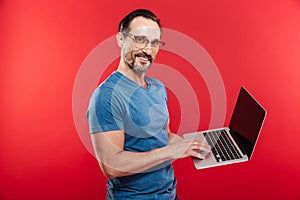 Happy emotional positive man using laptop computer.