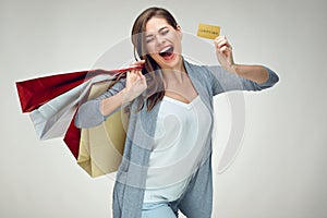 Happy emotional woman holding credit card and shopping bag.