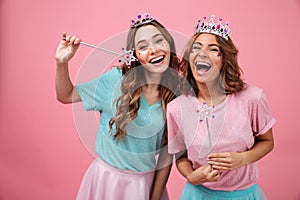 Happy emotional young women friends in princess costumes