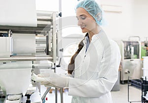 Happy employee wearing lab coat while handling sterile wipes