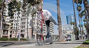 Happy employer in formalwear have fun riding escooter on sidewalk, recreation photo