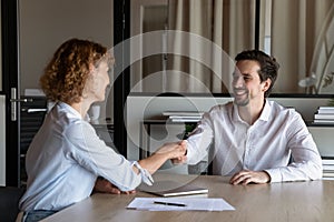 Happy employer hiring candidate after interview, congratulating on getting job