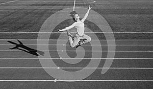 Happy energetic girl child jump on running track, athletics