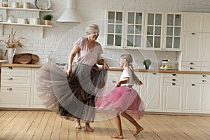 Happy energetic grandmother teach ball dances active little girl grandchild
