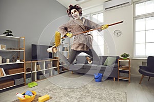 Happy energetic housewife playing on pretend mop guitar while tidying up her home
