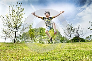 Happy energetic young boy jumping high in the air