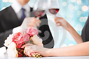 Happy engaged couple with flowers and wine glasses