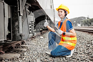 happy engineer women worker check service maintenance train wheel suspension confirm thumbs up good condition photo