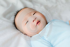 Happy and enjoy Portrait of a newborn Asian baby boy on the bed ,a dummy in his mouth, Charming