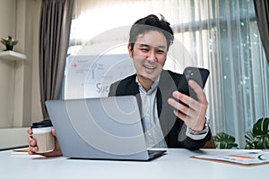 Happy entrepreneur businessman in formal wear work on laptop computer in office with smile face. Attractive business owner man tal