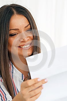 Happy entrepreneur woman reading good news in a letter on sofa