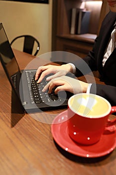 Woman hands working with a laptop in a coffee shop