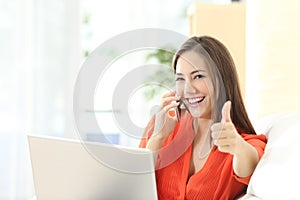 Happy entrepreneur working with thumbs up photo