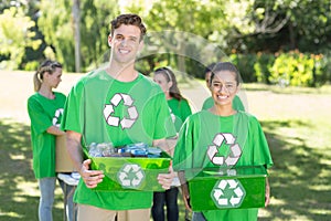 Happy environmental activists in the park with recyclables